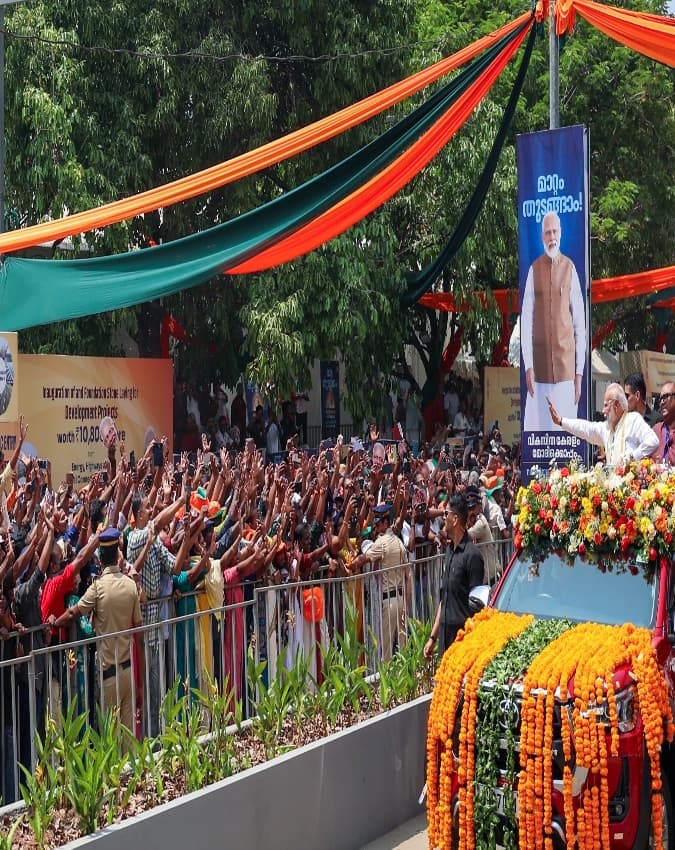 लोगों का अभिवादन करते हुए पीएम मोदी
