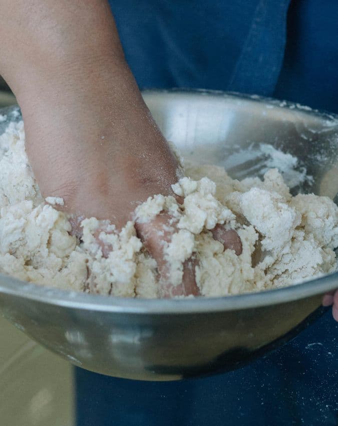 गर्म पानी से आटा गूंथना 