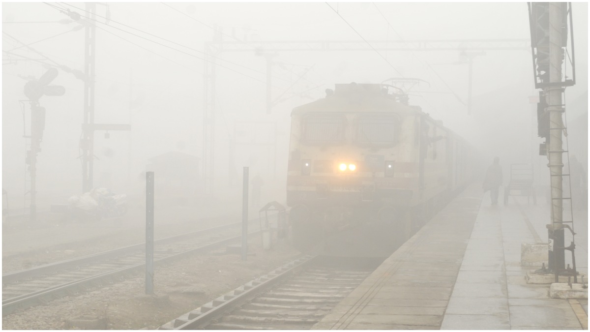 A train runs on the track amid the dense fog