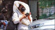 A girl uses a scarf to protect herself from the heat