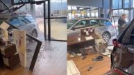 man drives car into showroom