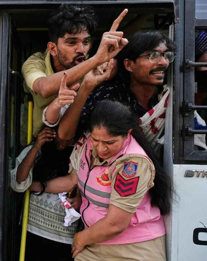 प्रदर्शनकारियों को बस में ले जाती पुलिस